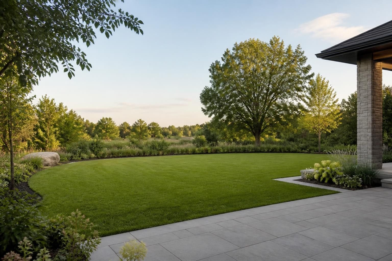 Finished backyard landscape with open lawn and patio edge.